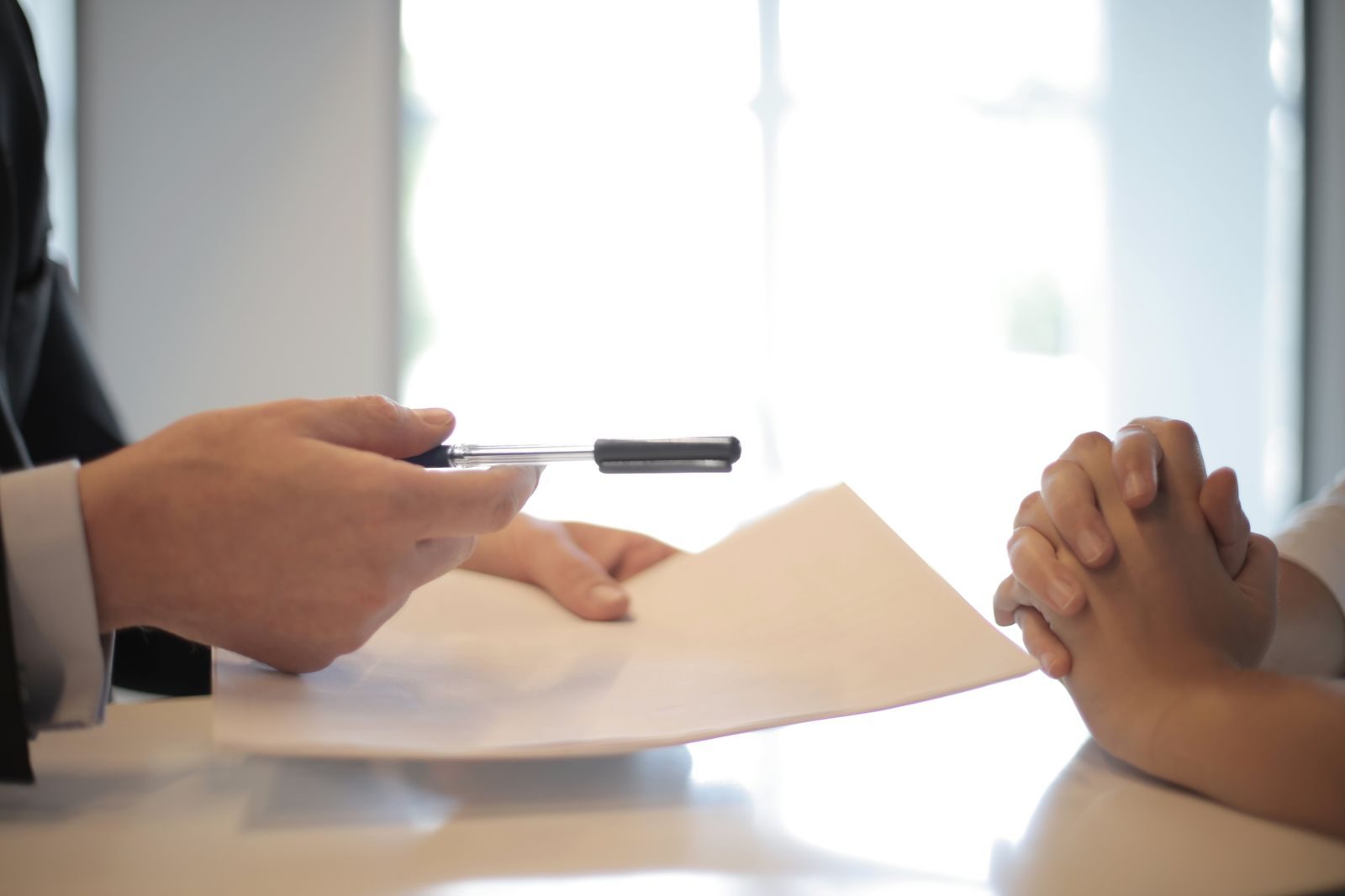 Broker handing finalized policy documents to a client