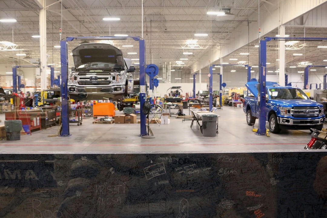 Mechanic inspecting a damaged customer vehicle inside an auto repair shop