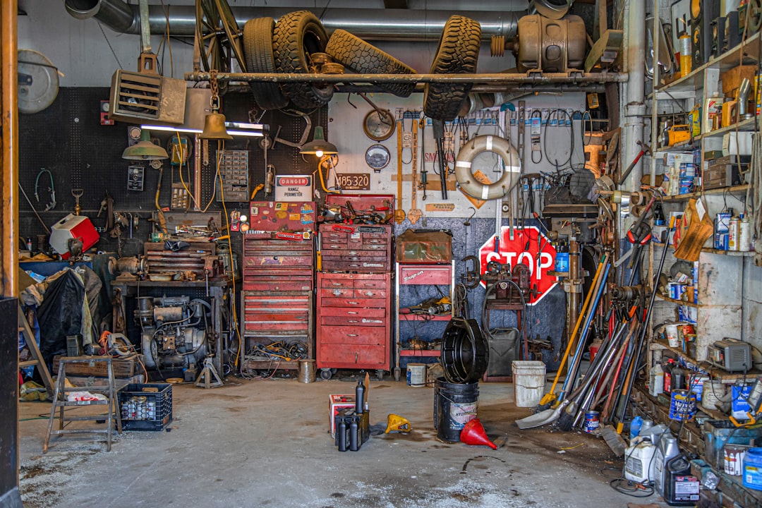 Mechanic working under a lifted vehicle in a service bay — auto repair shop insurance cost