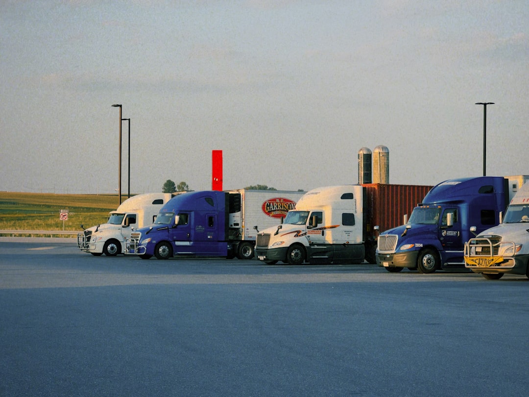 Fleet of semi-trucks in a commercial trucking yard reflecting insurance cost considerations