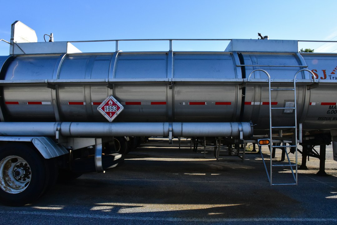 Placarded hazmat tanker truck on a US highway, illustrating hazmat trucking insurance requirements